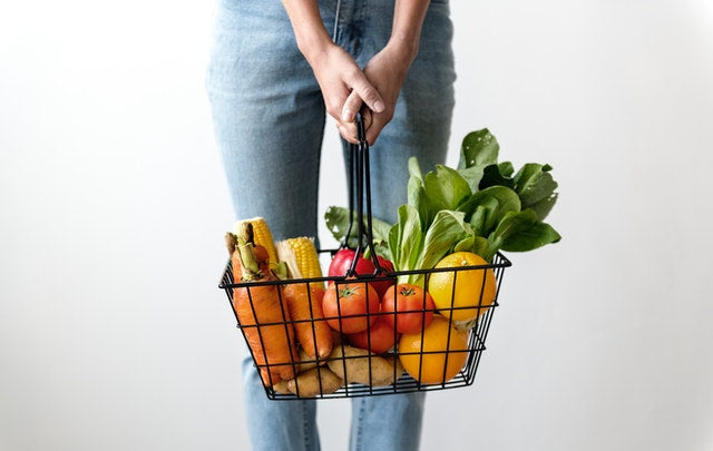 Person holding basket full of healthy foods